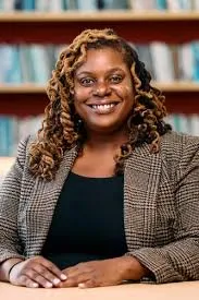 picture of Woodly seated at a desk